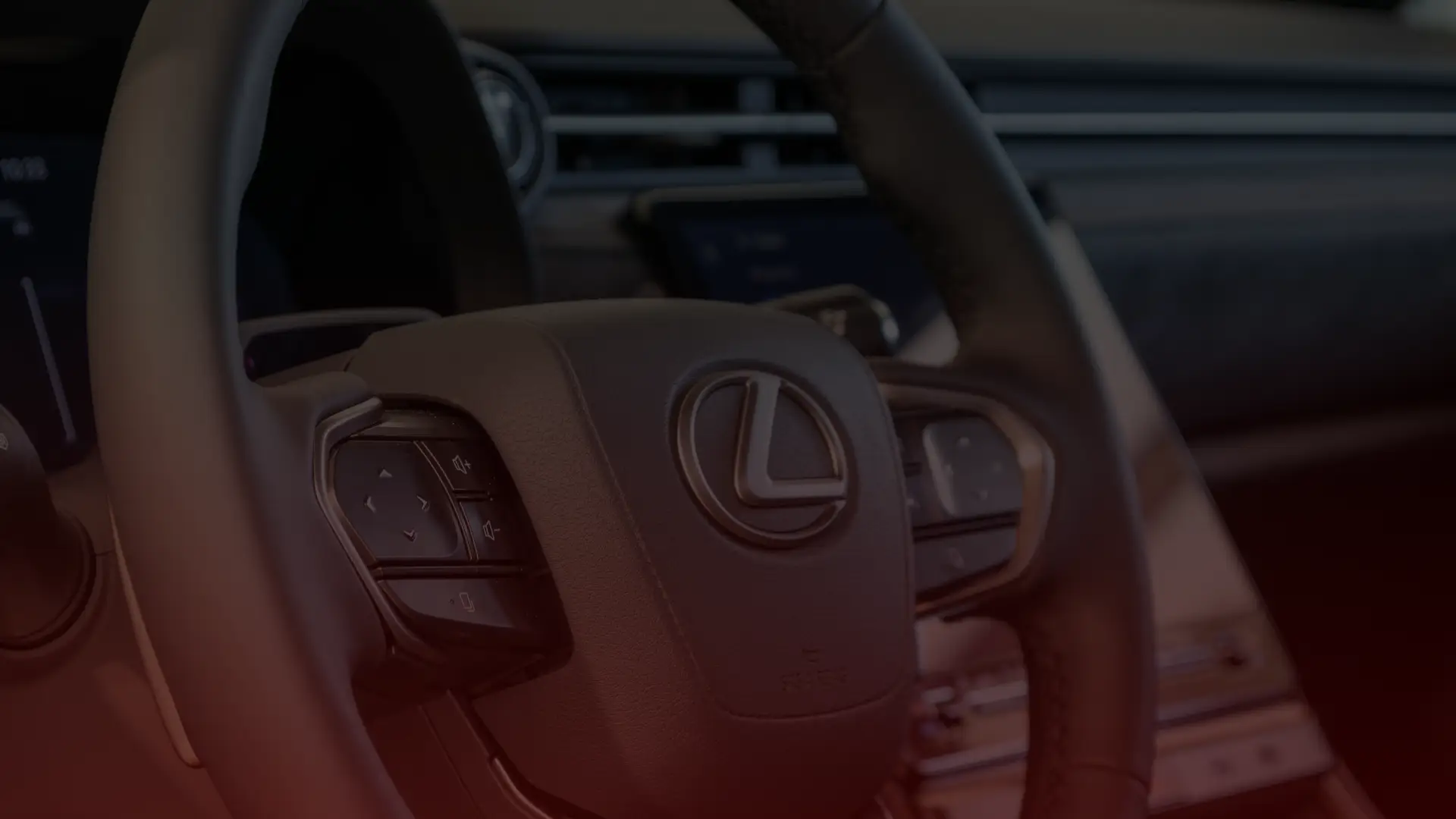 Close-up of a car steering wheel featuring the Lexus logo in the center. The wheel, reminiscent of designs admired by any Acura mechanic in Scarborough, boasts multiple control buttons. In the dimly lit background, a partially visible screen on the sleek dashboard adds to its modern allure. EuroMechanic | Redline Automotive | Top Reviewed Auto Repair Shop in Scarborough | Visit redlineautomotive.ca