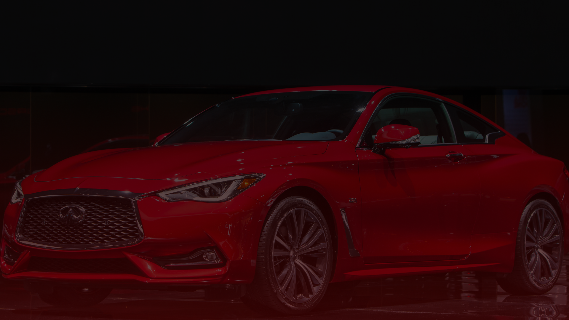 In a dimly lit Scarborough showroom, a sleek, red sports car is displayed. It features aerodynamic lines, a distinctive grille, and shiny alloy wheels that reflect the light. Like a carefully tuned masterpiece by a Toyota mechanic, the car conveys a sense of speed and luxury. EuroMechanic | Redline Automotive | Top Reviewed Auto Repair Shop in Scarborough | Visit redlineautomotive.ca