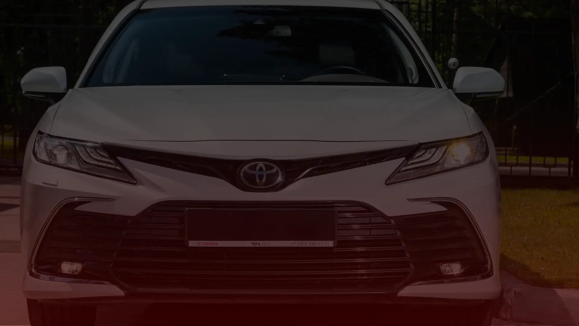 Front view of a white Toyota sedan with sleek headlights and a prominent front grille, parked outdoors, showcasing the precision admired by every Toyota mechanic in Scarborough. EuroMechanic | Redline Automotive | Top Reviewed Auto Repair Shop in Scarborough | Visit redlineautomotive.ca