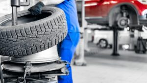 Winter tires mounted on separate steel rims beside unmounted winter tires at an automotive shop